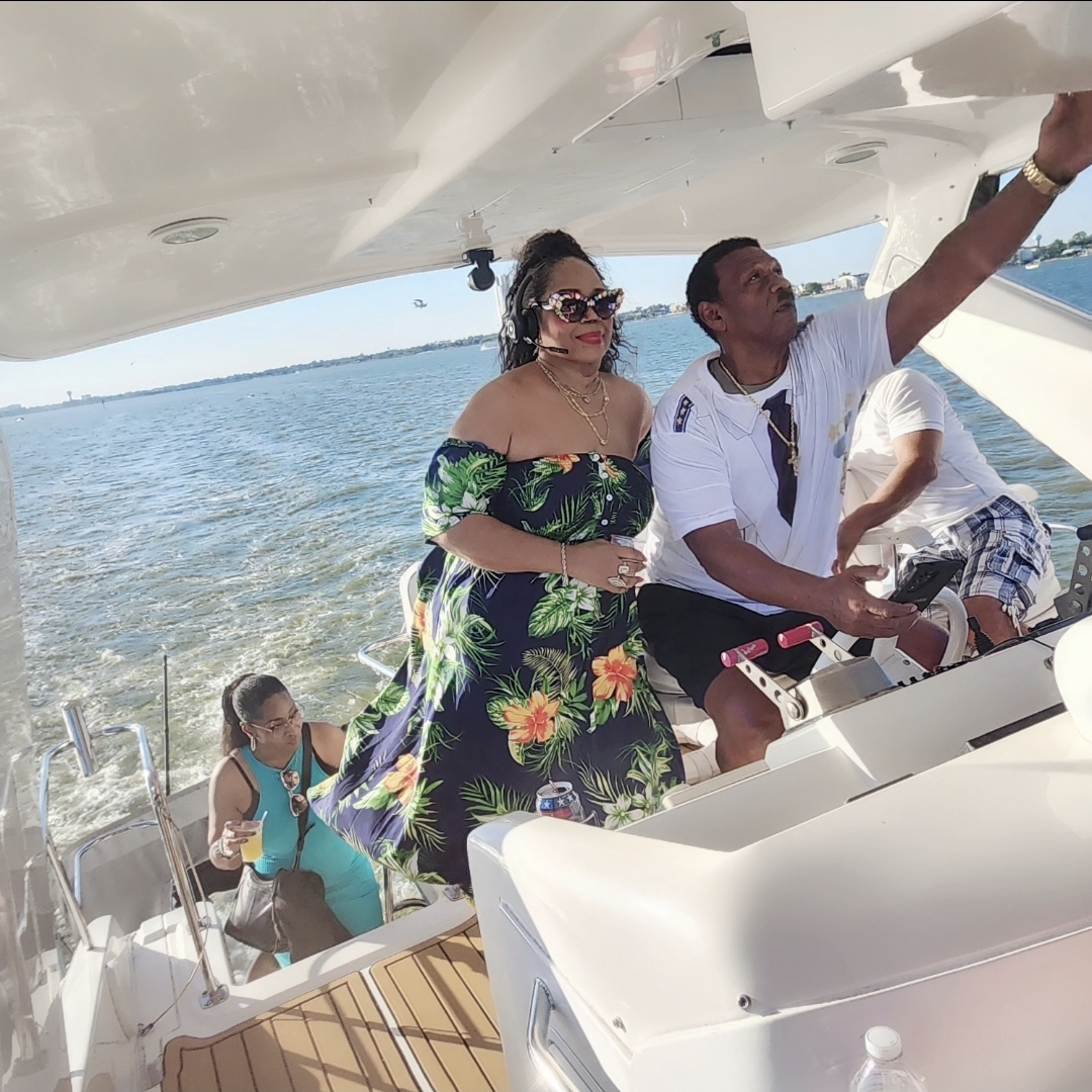 Guests at the helm as the yacht cruises